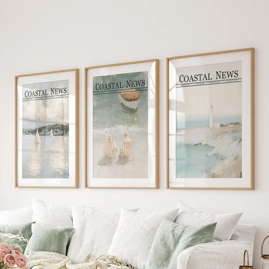 Seaside scenes make up a wall art trio in matted wooden frames, displayed behind a couch in a family room.