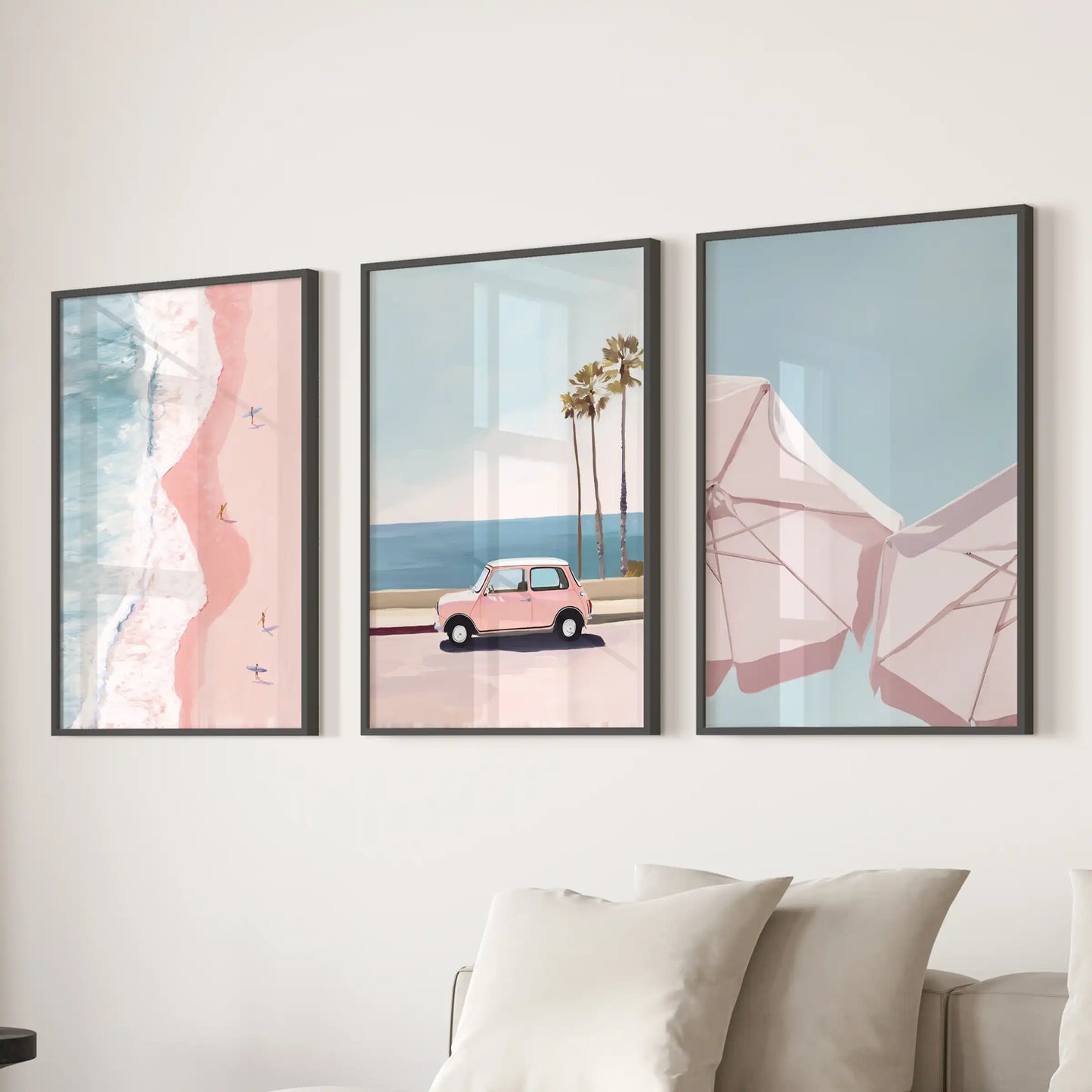 Slim black-framed wall art of pink coastal beach scenes forms a bright 3-panel centerpiece behind the sofa in the family room.