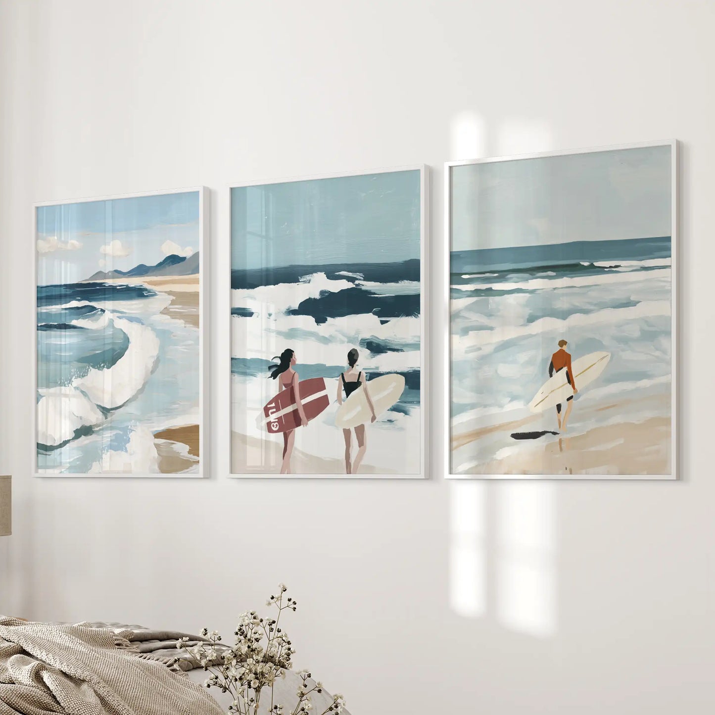 Surfer wall art set of three in crisp white frames, displayed near the bed wall for an airy, relaxed bedroom feel.