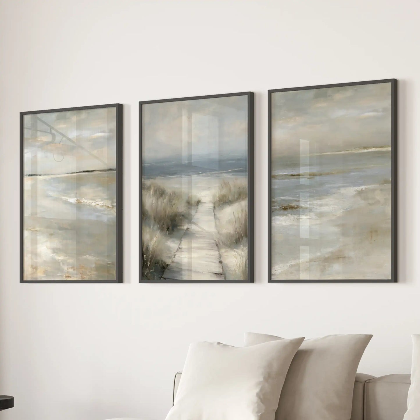 Three framed ocean horizon pieces in black frames anchor the family room above the sectional sofa, wrapping it in serene neutral tones.