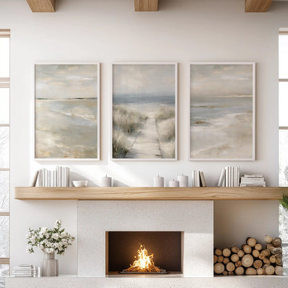 White-framed trio of neutral coastal wall art centers the sitting room over the mantelpiece, balancing soft tones and open sky.