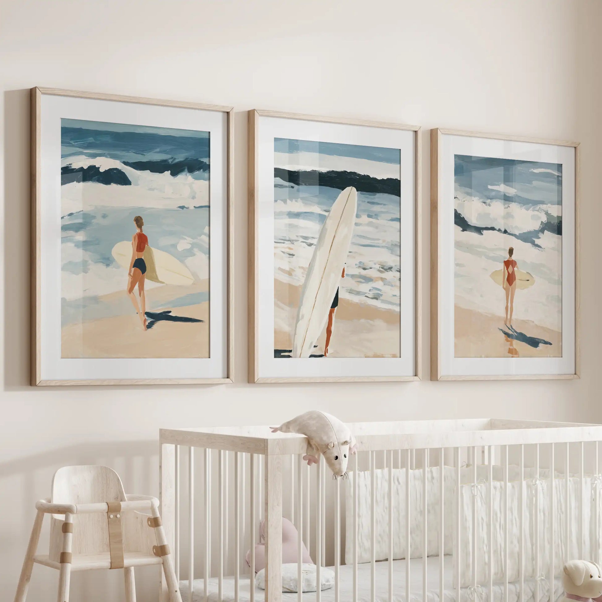 Three thin wood-framed surfer art prints with mats lend a gentle seaside touch over the cot in the baby room.