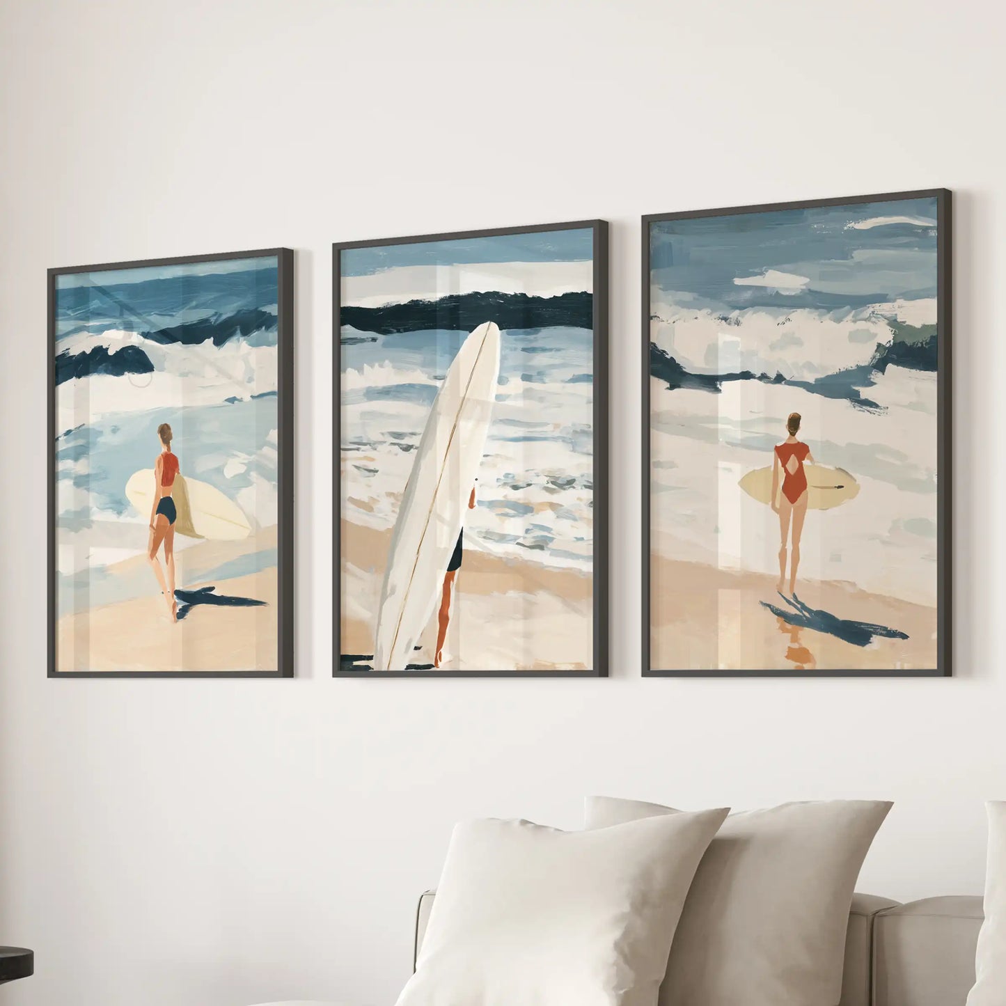 A trio of coastal beach wall prints, each in a black frame, steadies the family room behind the sofa with airy sea-washed color.