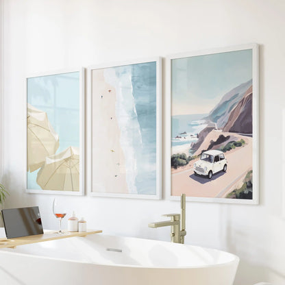 Three white-framed beach-umbrella pictures bring seaside cheer to a bathroom wall, brightening the space above the tub.