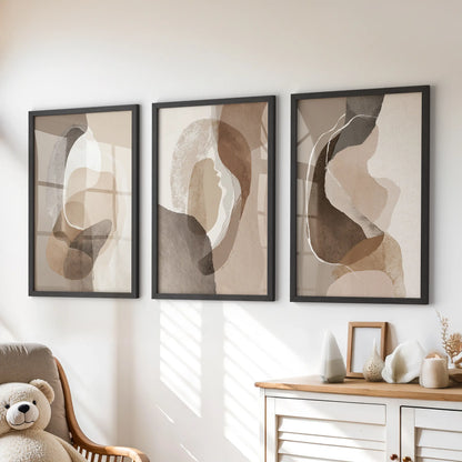Neutral abstract wall art three-print set, black framed, rests over the chest of drawers to add soft earth tones to a children’s room.