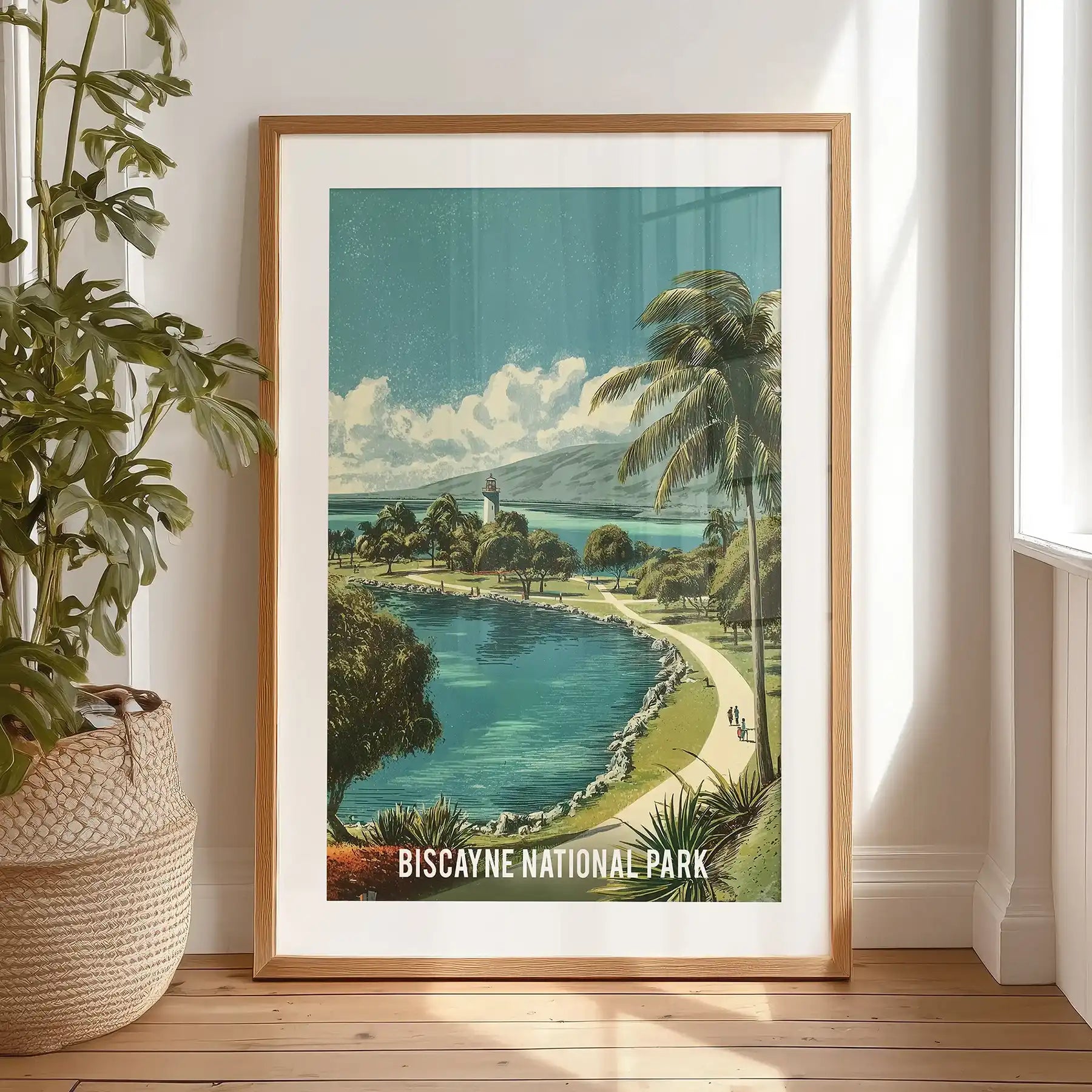 A black-framed coastal landscape print, matted and resting on the bedroom floor, portrays Biscayne’s clear bay water and soft retro shoreline.