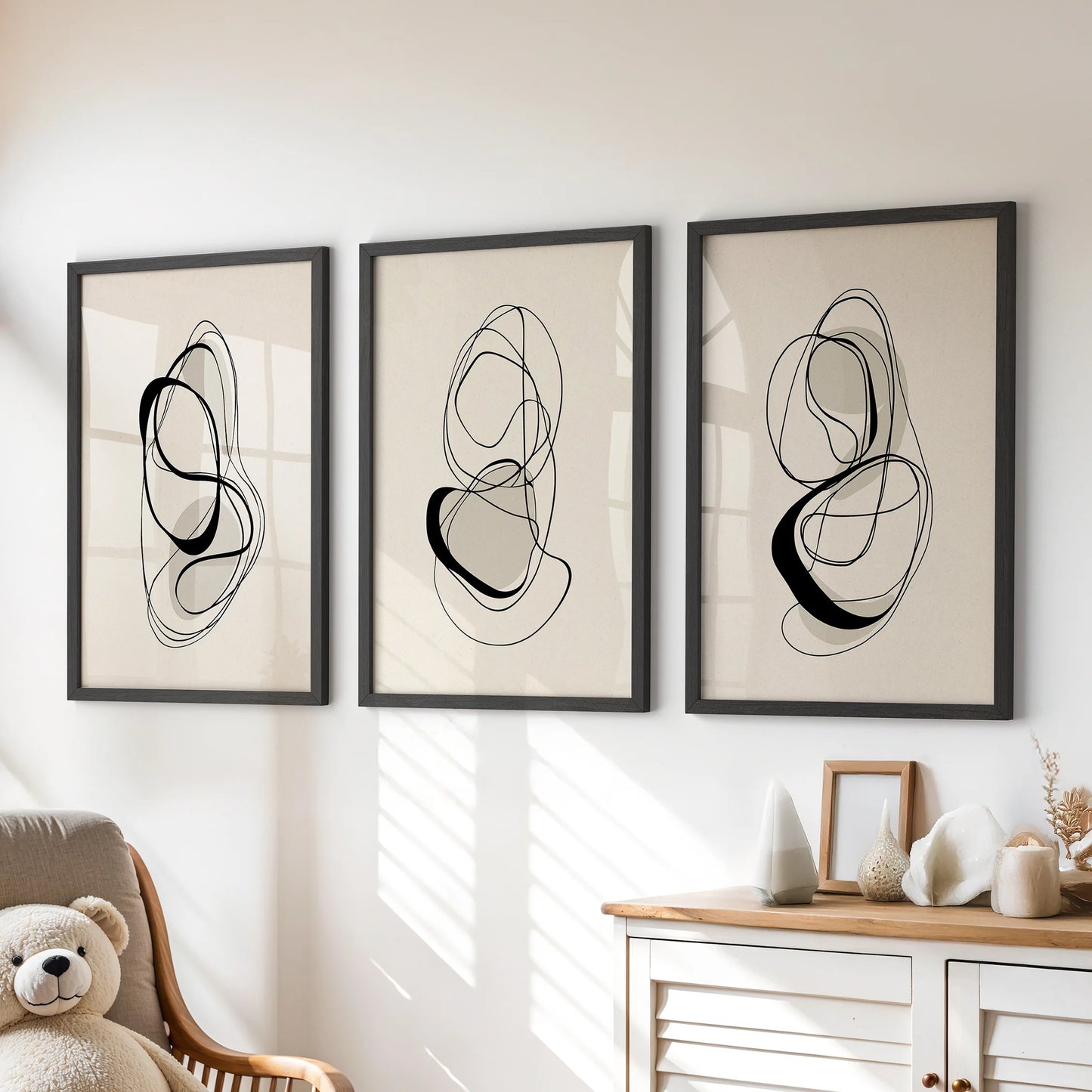 Contemporary line illustrations, three-piece wall art, black framed and mounted above the chest of drawers to soften a children’s room with calm neutrals.