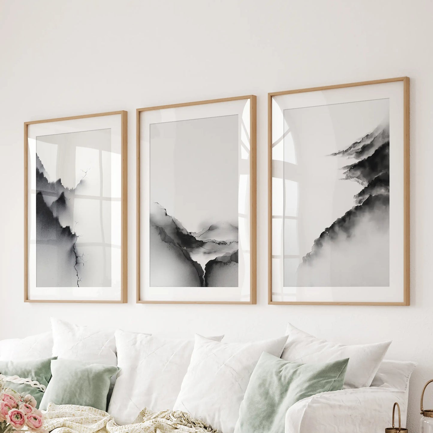 Three oak-matted art prints of watercolor landscapes soften the family room wall over the couch with subtle tonal contrast.