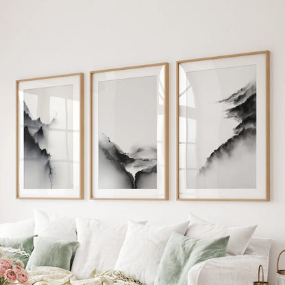 Three oak-matted art prints of watercolor landscapes soften the family room wall over the couch with subtle tonal contrast.