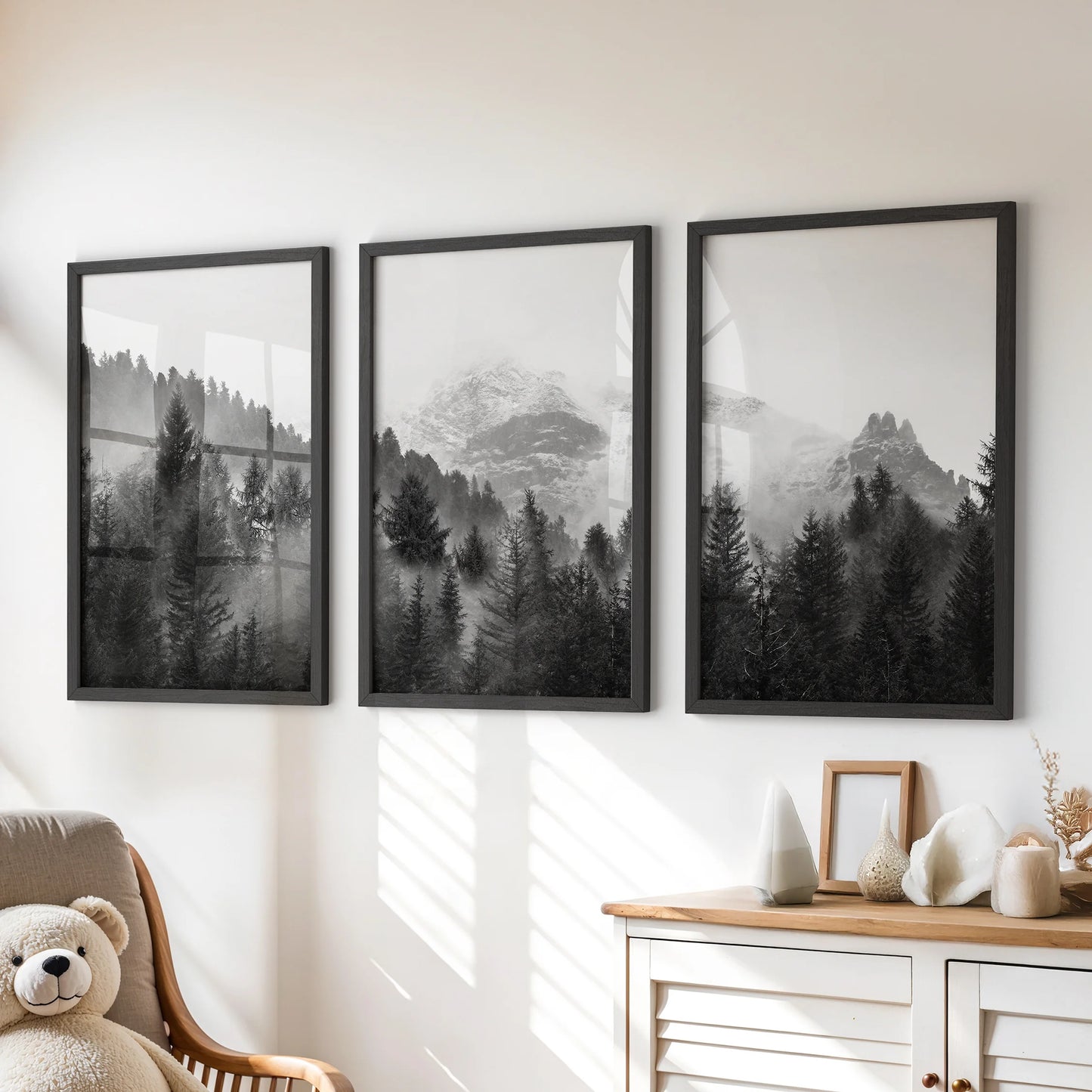 Three black-framed forest art prints with a hazy tree line bring calm style to a playroom wall above a chest of drawers.