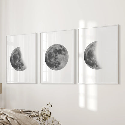 Moon phases sequence set of three prints in white frames hangs on the bedside wall, adding soft monochrome lunar art to the bedroom.