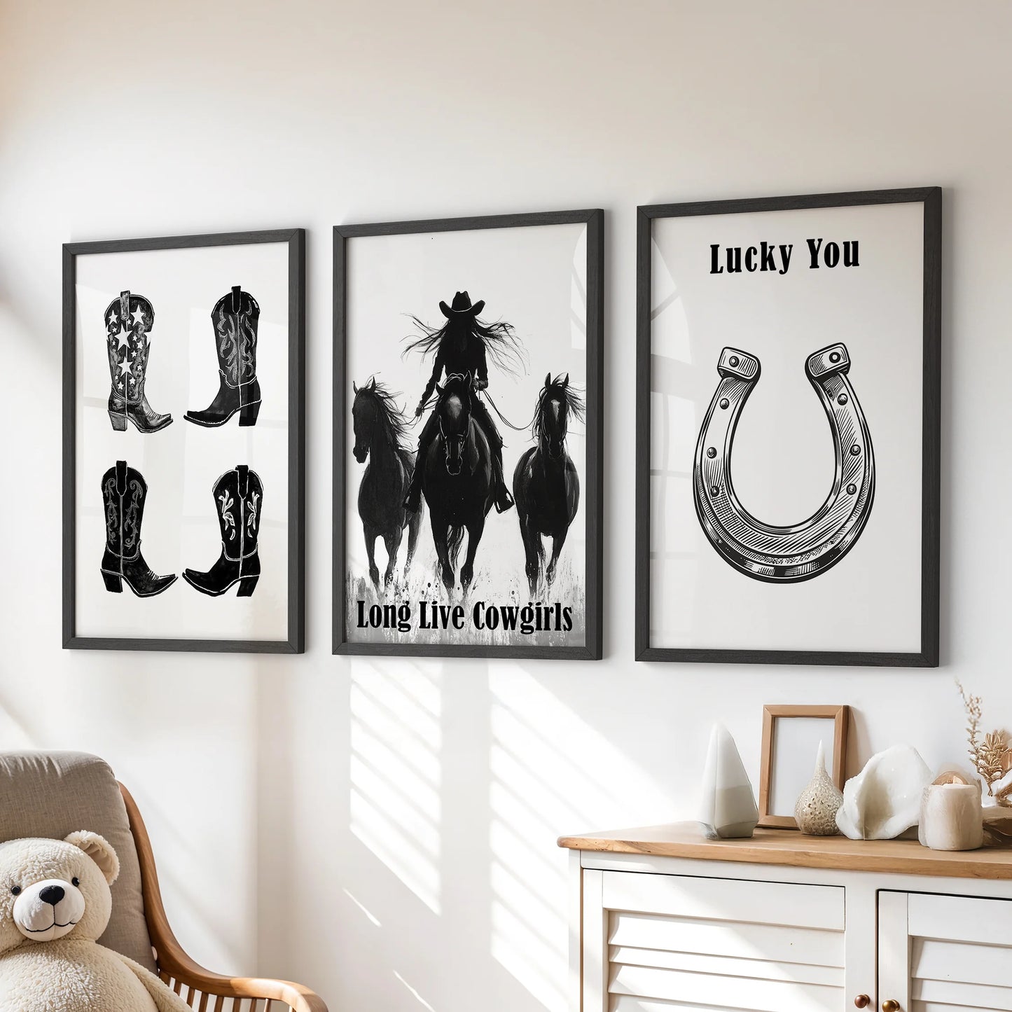 Black-and-white horseshoe art prints, a playful three-piece wall set, hang above the playroom dresser in polished black frames.