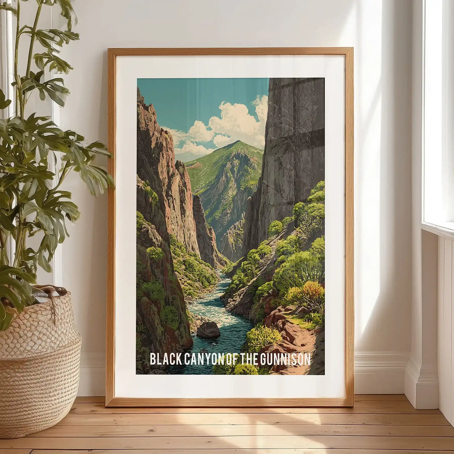 Colorado national park scenery wall decor with a black frame and matting leans casually on a bedroom floor, creating a bold vertical accent behind the bed.