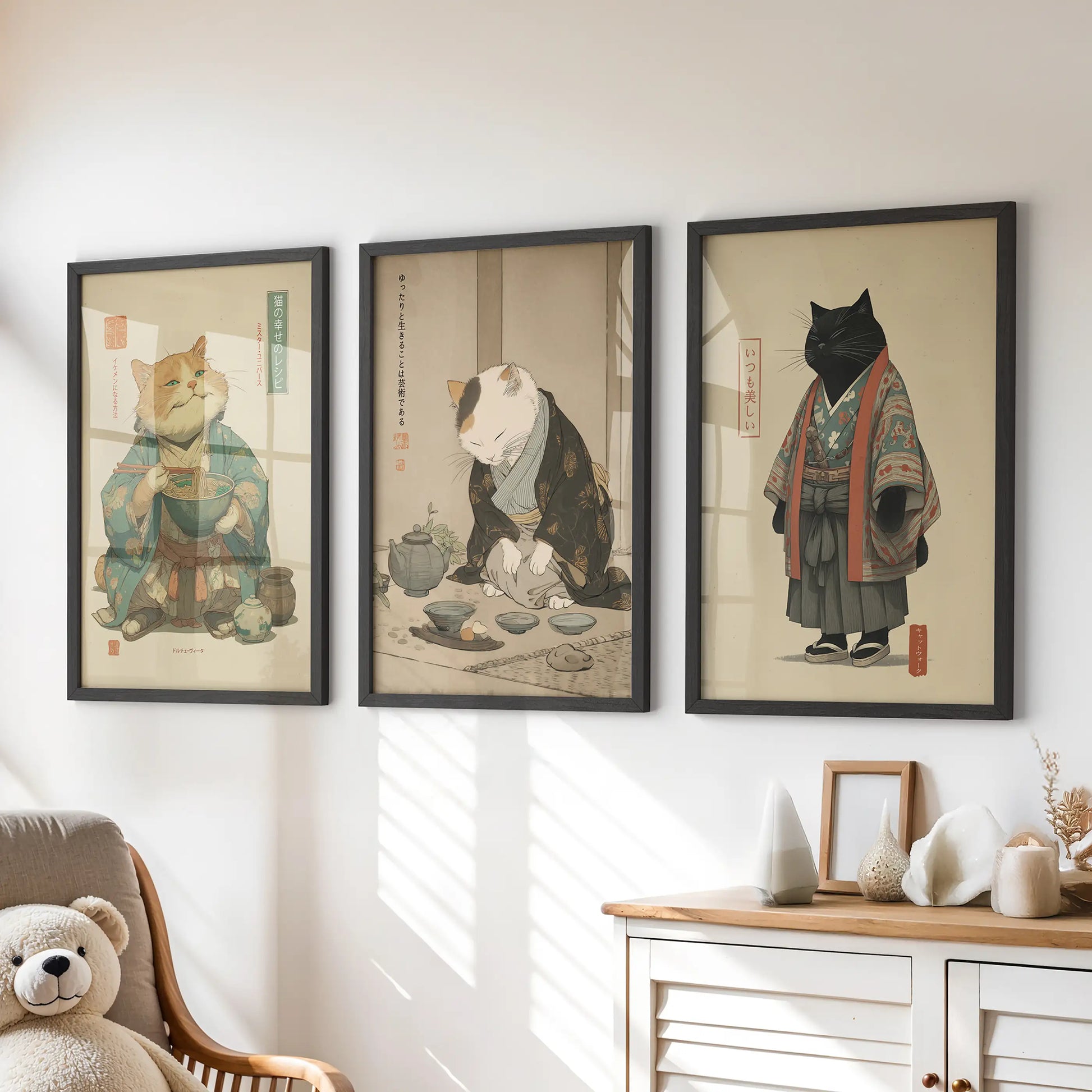 A playful trio of black-framed cat artworks featuring a ramen bowl hangs above the children's drawers, bright with storybook charm.