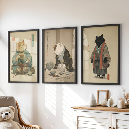 A playful trio of black-framed cat artworks featuring a ramen bowl hangs above the children's drawers, bright with storybook charm.