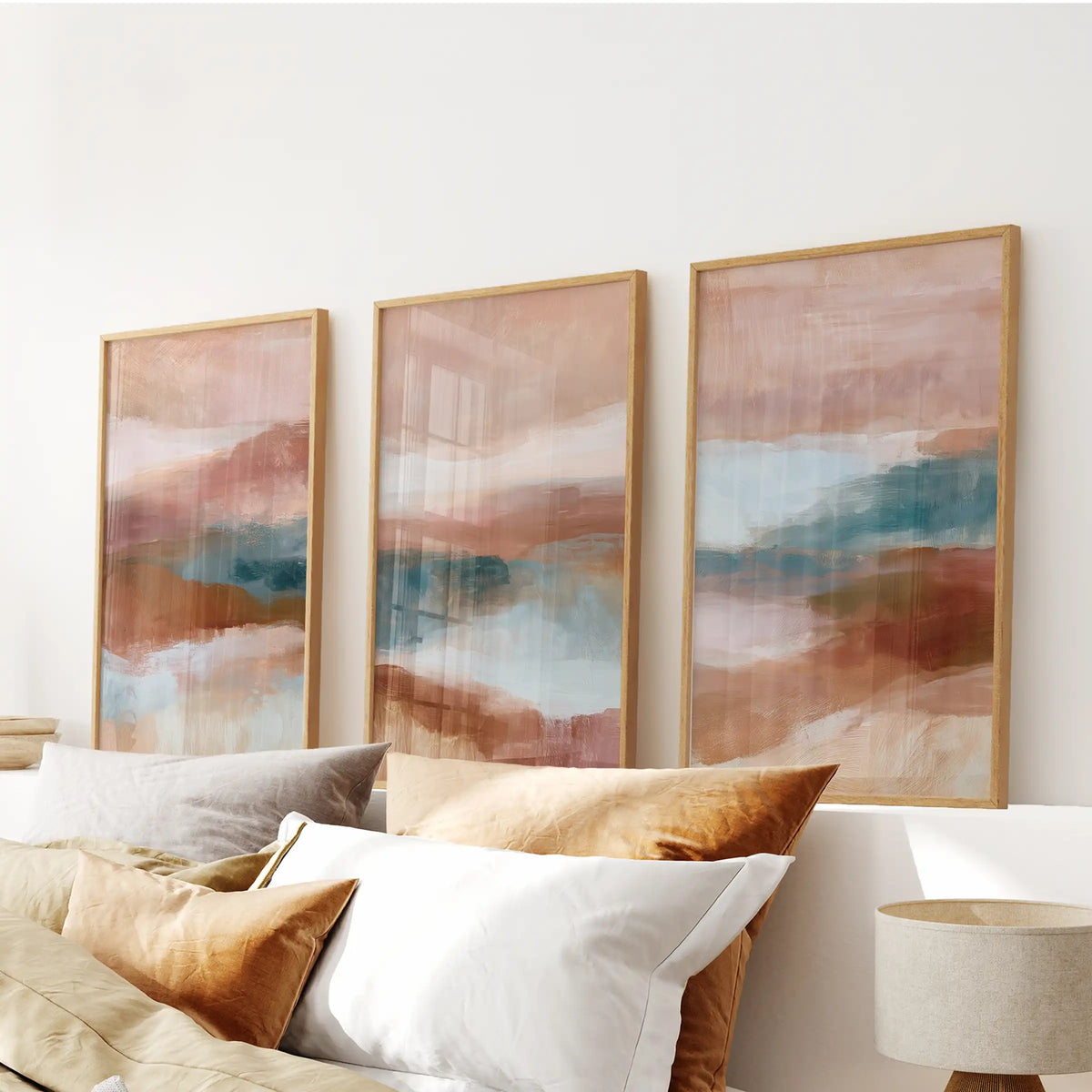 Textured minimalist forms, a set of three art prints in warm wood frames, sit over the bedroom headboard and add a soft hit of color.