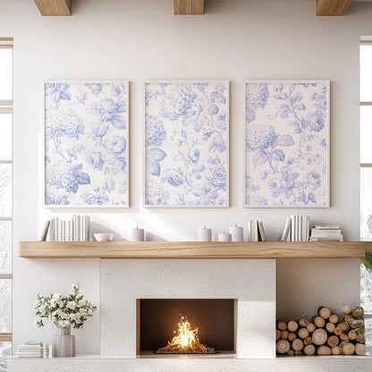 Three blue botanical pattern prints hang above a fireplace, framed in white.