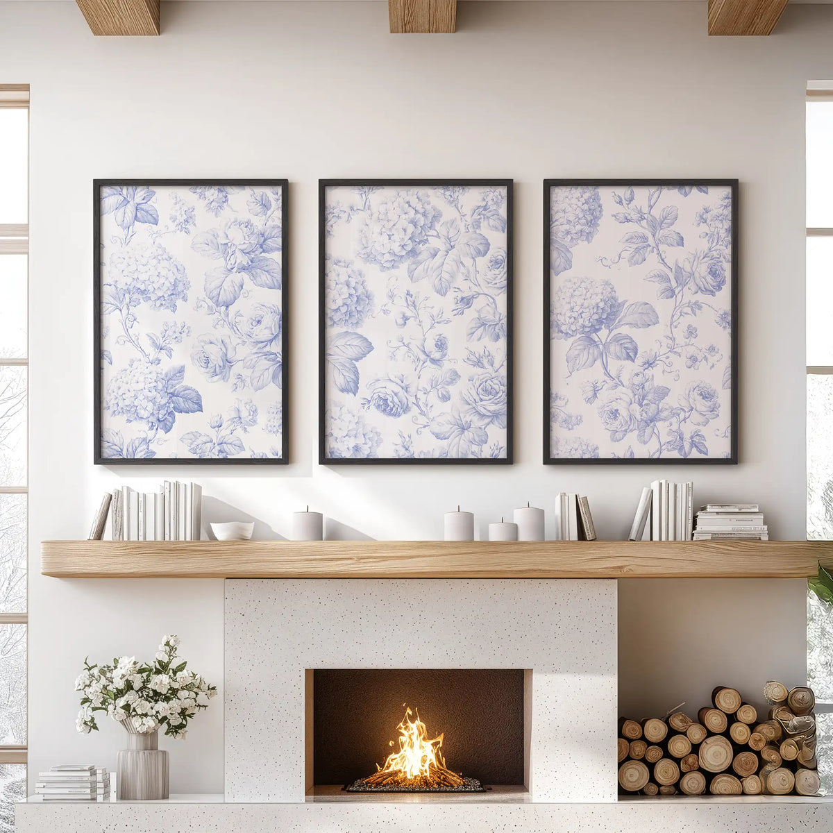 Blue roses and round hydrangea clusters spread through fine leafy stems across three black-framed prints above a fireplace.