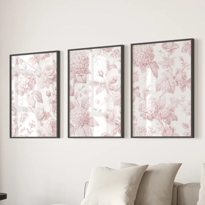 The three black-framed prints above a sofa are filled with pink roses and hydrangeas, linked by fine leafy stems on cream backgrounds.