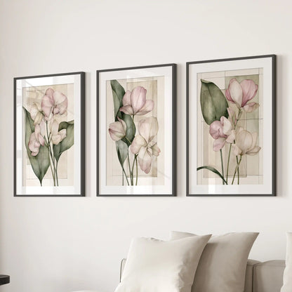 Matted black frames display three pink botanical flower prints above a sofa.