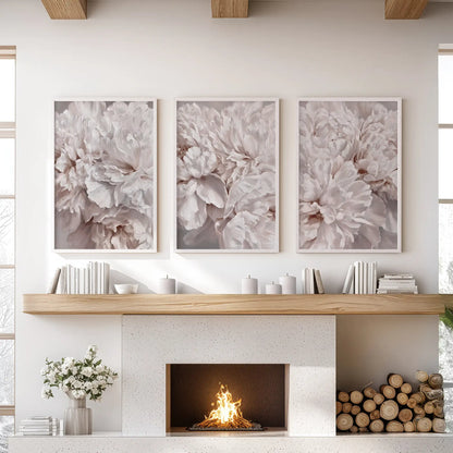 White frames surround three peony close-ups above the fireplace mantel, showing pale pink petals and deeper taupe folds.