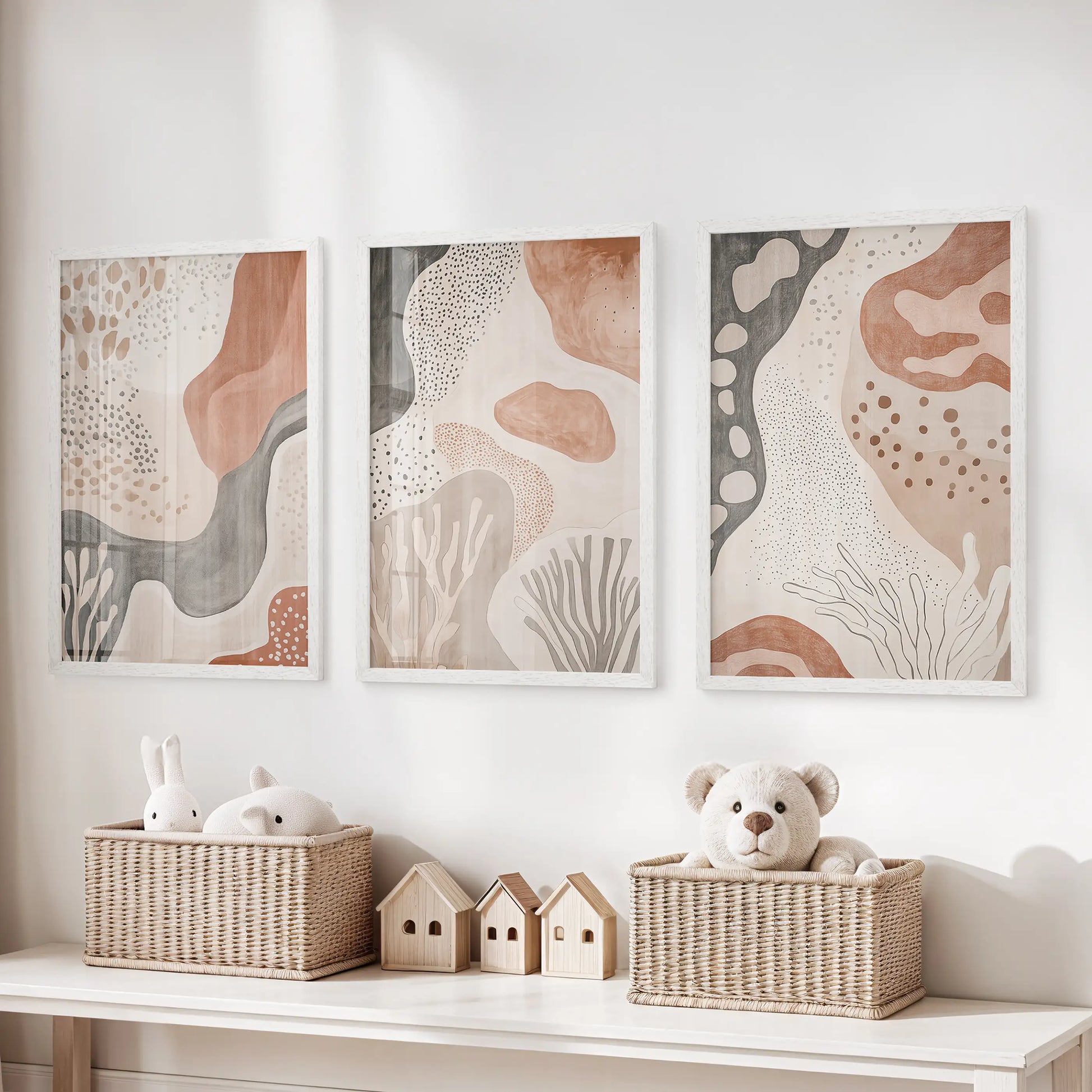 White-framed trio of minimalist prints lines up over the toy bench, adding gentle structure to the kids’ playroom.