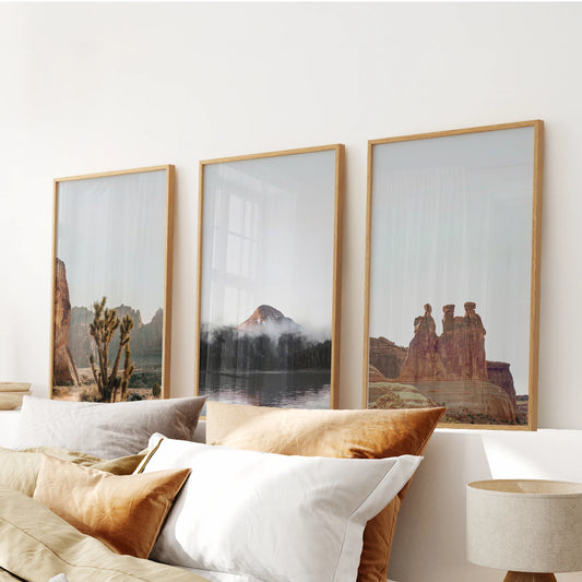 Wood-framed wall hanging of three desert prints featuring sandstone arches and buttes crowns the bedroom above the headboard.