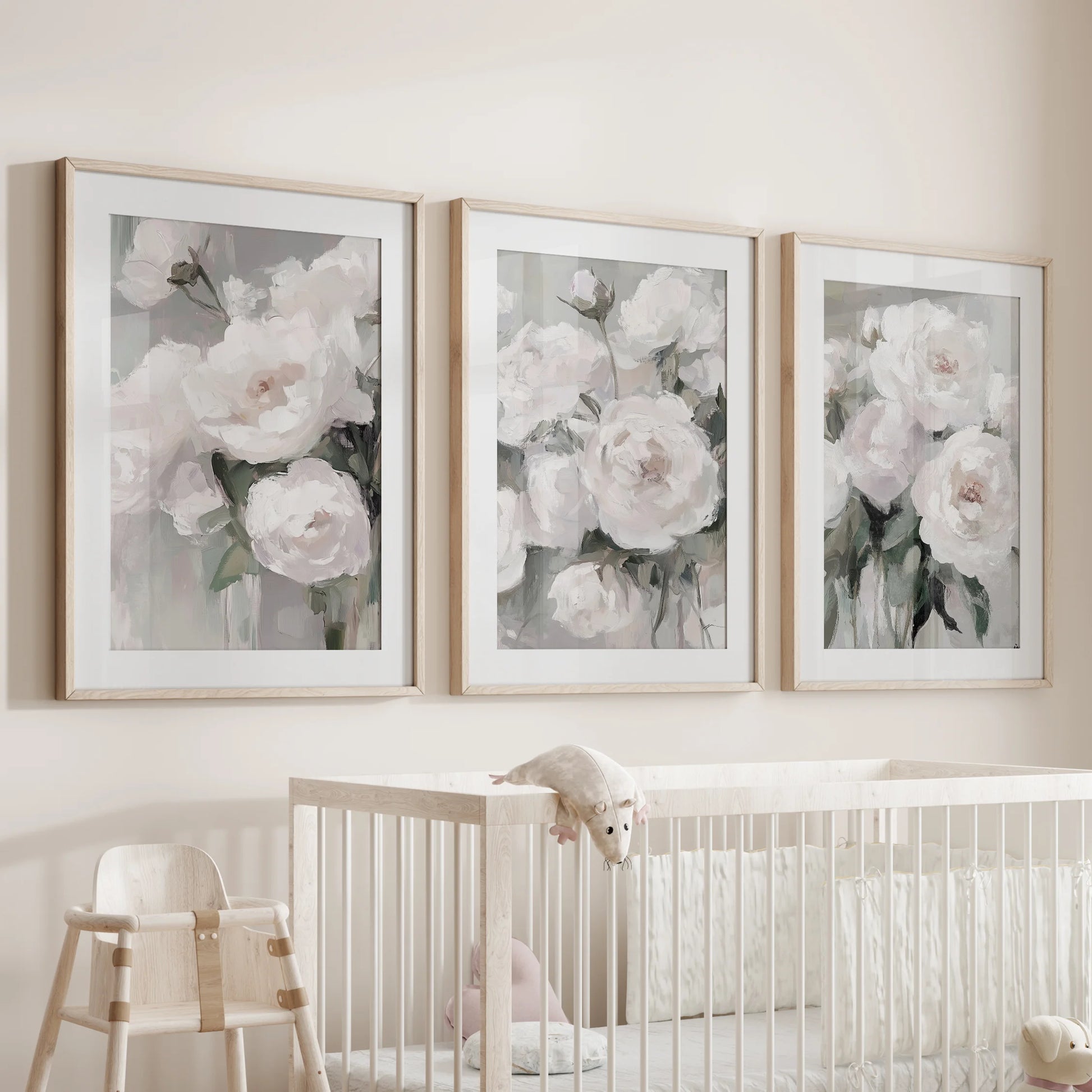 Three wood-framed floral artworks, soft-matted for depth, float gently above the nursery cot, creating a soothing botanical focal point.