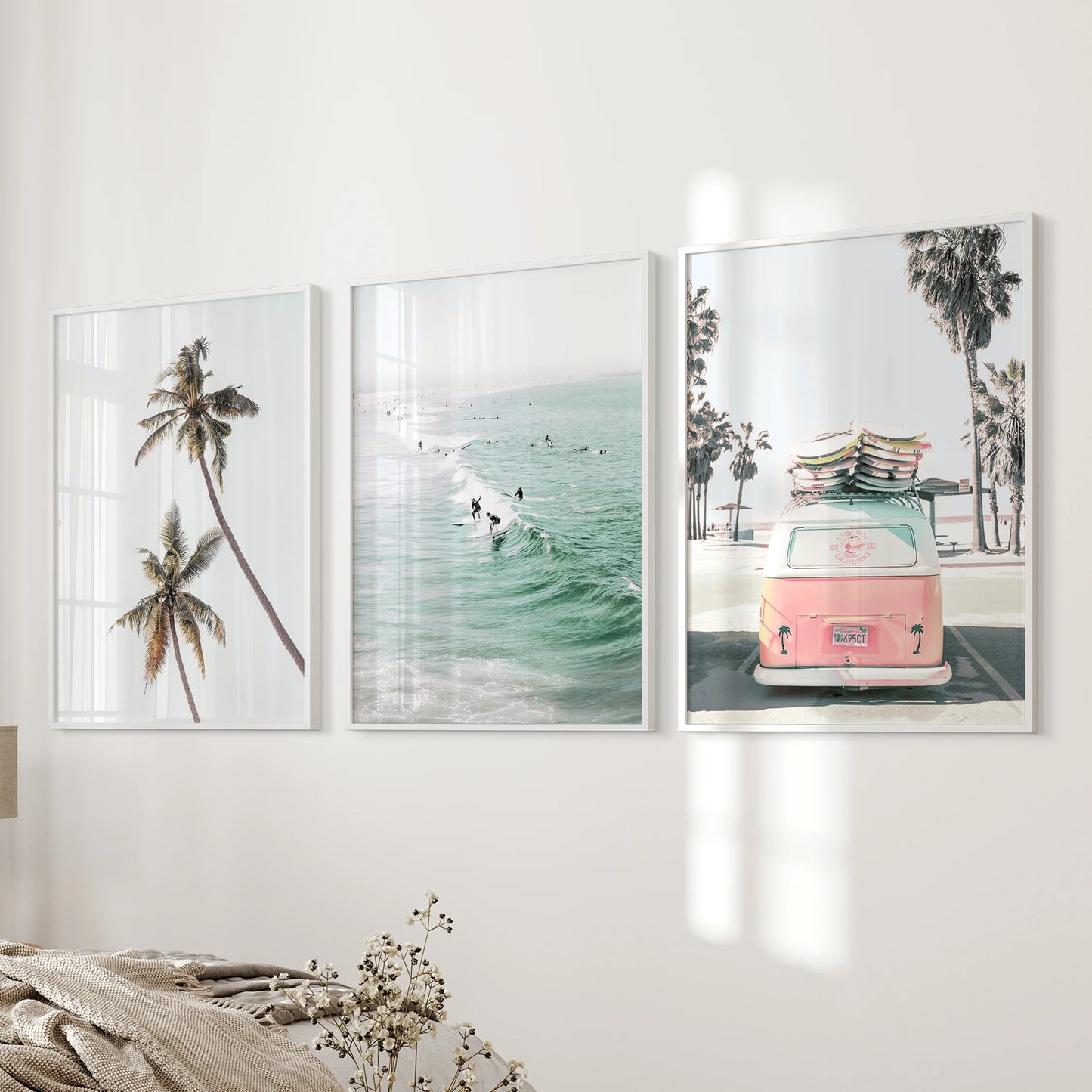 Pink camper van on the beach 3-piece art set adds playful color to the bedroom, hung in white frames along the bedside wall.