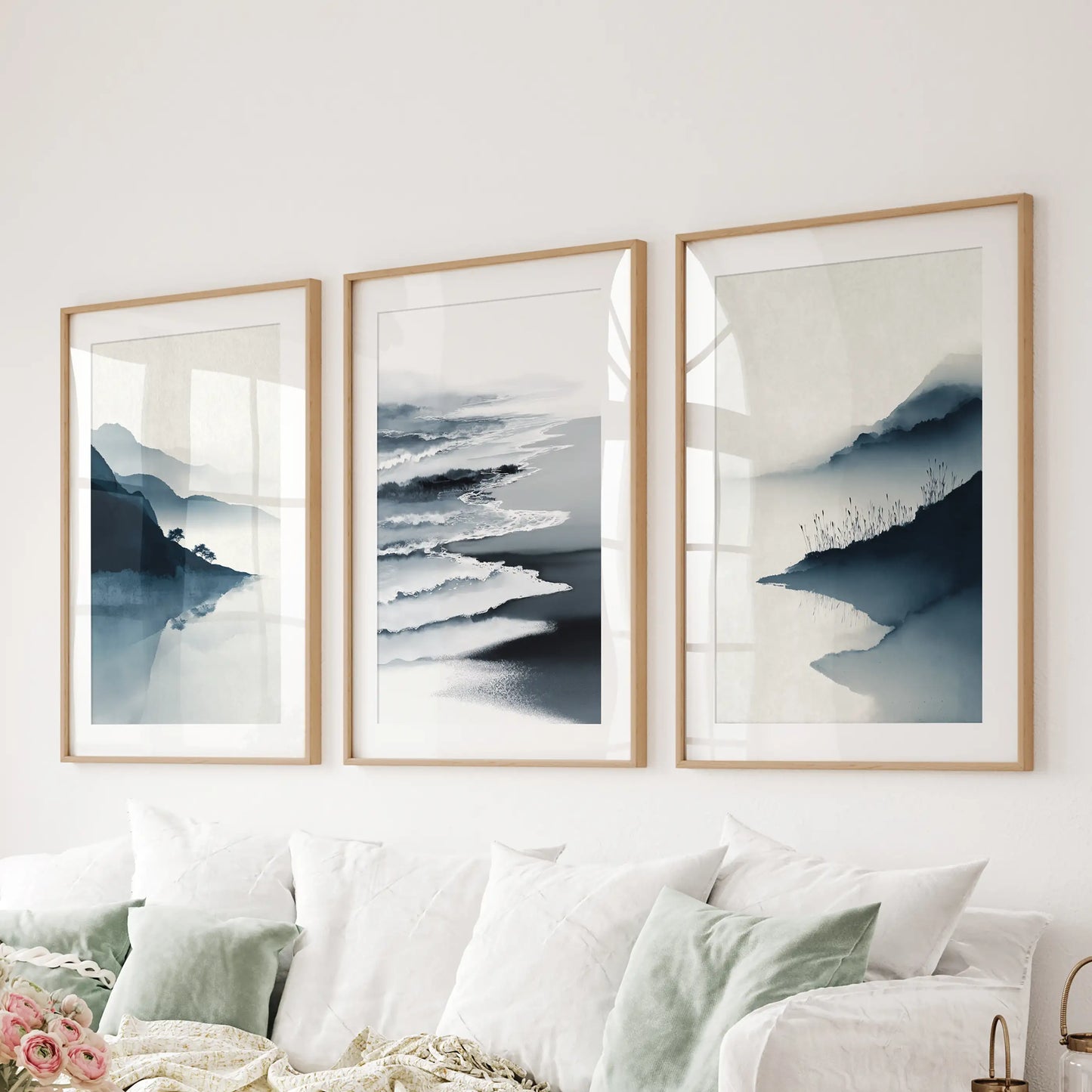 A 3-panel ocean scene spans the lounge above the sectional, wood-matted frames lending a tailored coastal refinement.