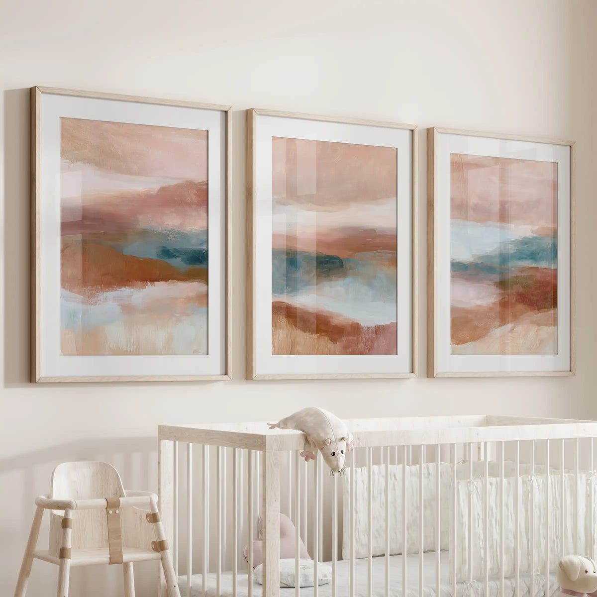 Earth-tone abstract triptych, an art trio in oak frames with mats, brings gentle warmth to the nursery when hung above the cot.