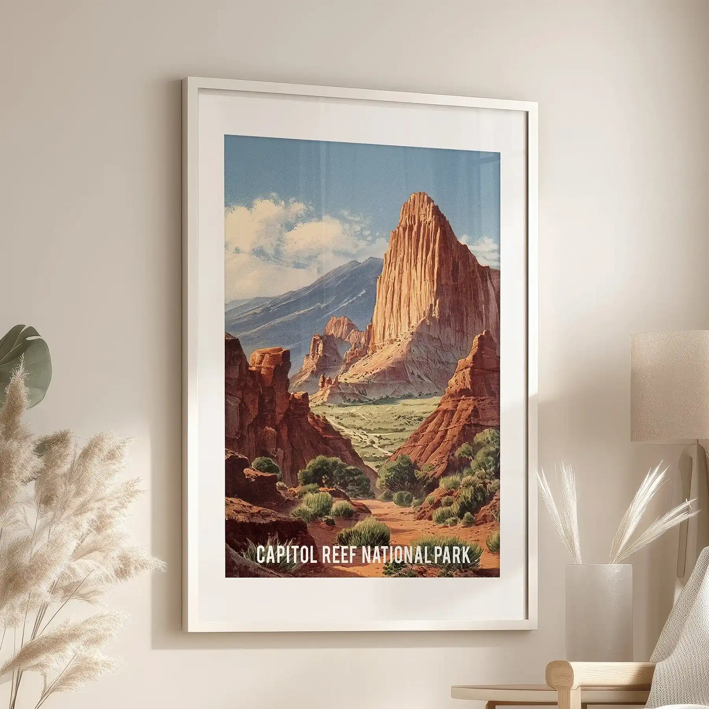 Single poster print of sunlit sandstone ridges, framed with a white mat, glows above a lounge chair to warm the room with desert tones.
