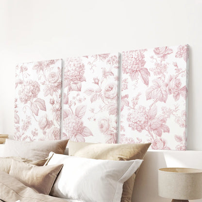Pink rose and hydrangea patterns cover three canvases above a bed.