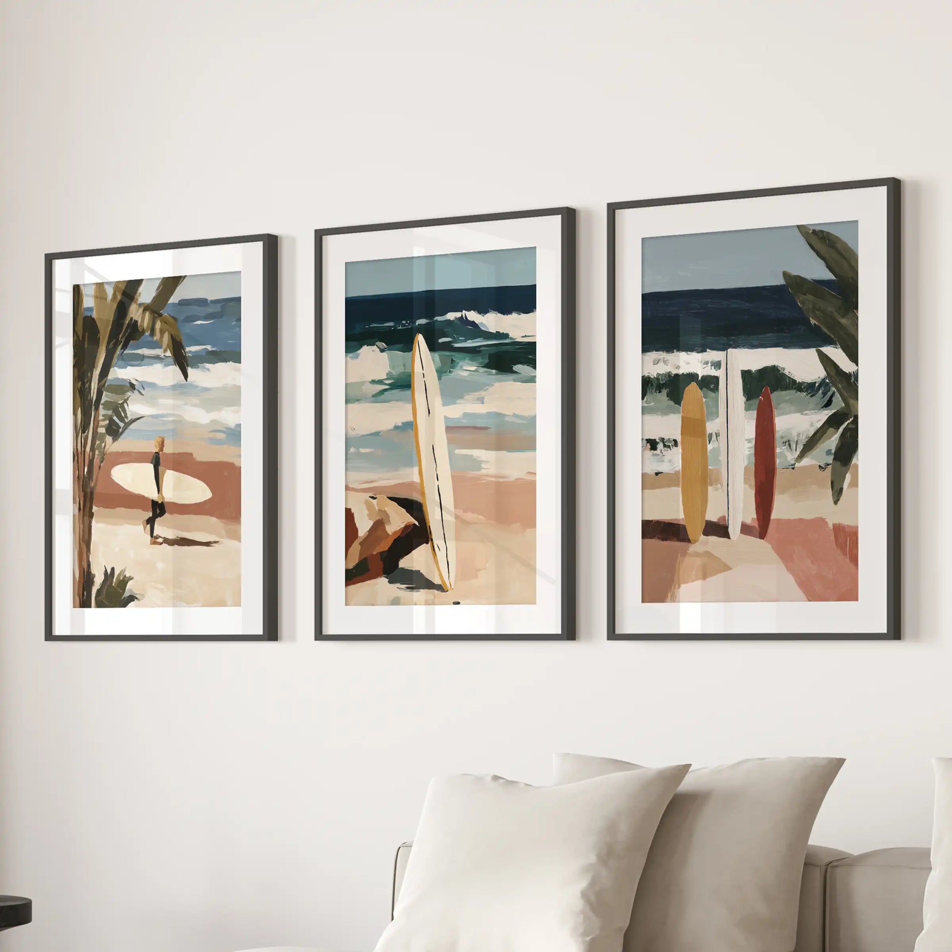 Three ocean-wave art prints in matted black frames hang above the sitting-room couch, lending a modern, breezy coastal feel.