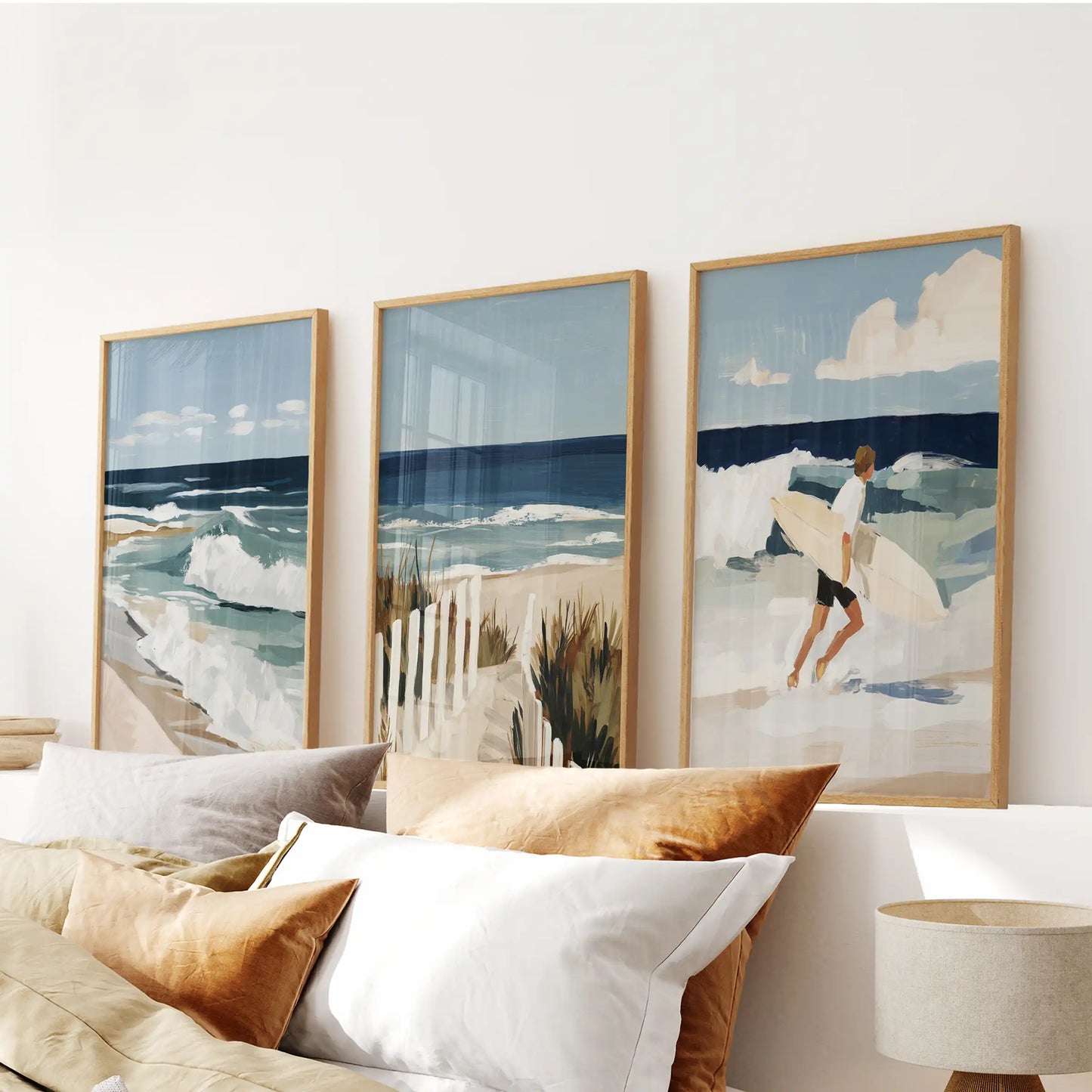 A gallery wall of three seaside prints in slim wood frames calms the bedroom, framed neatly above the bed.