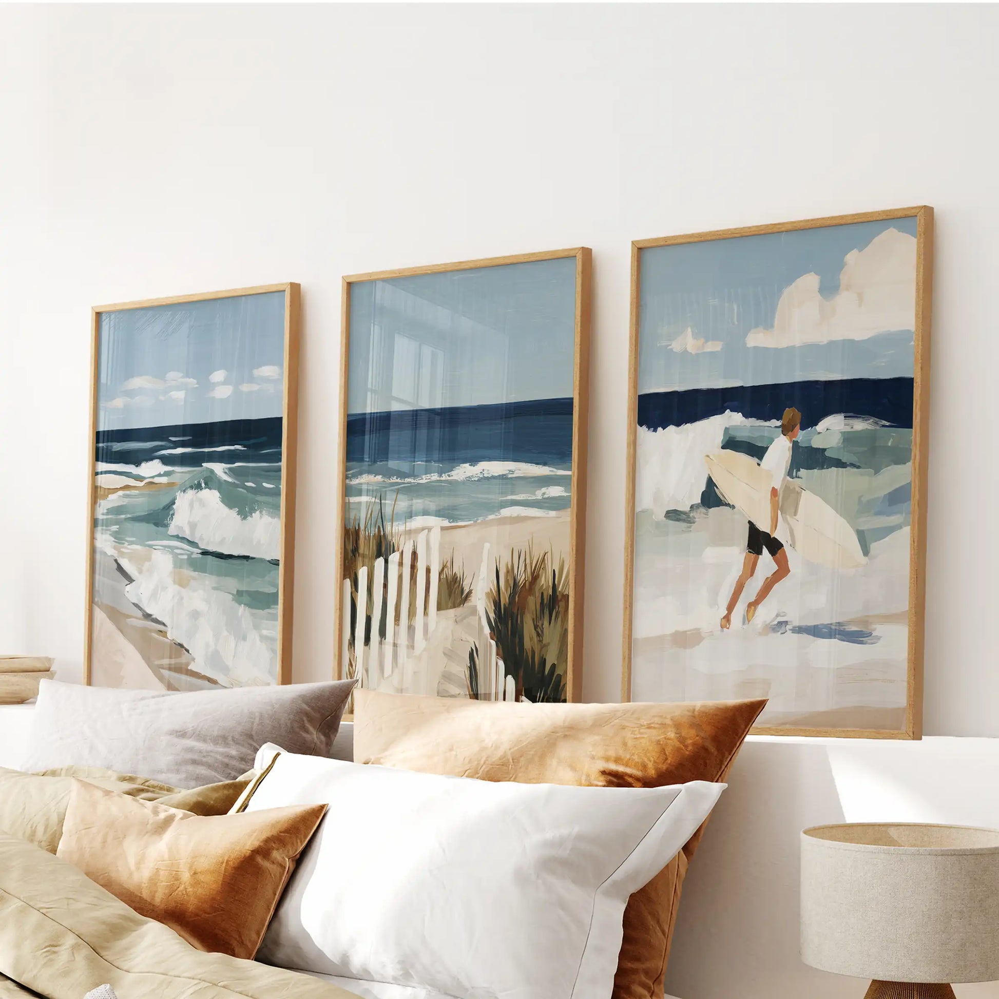 A gallery wall of three seaside prints in slim wood frames calms the bedroom, framed neatly above the bed.