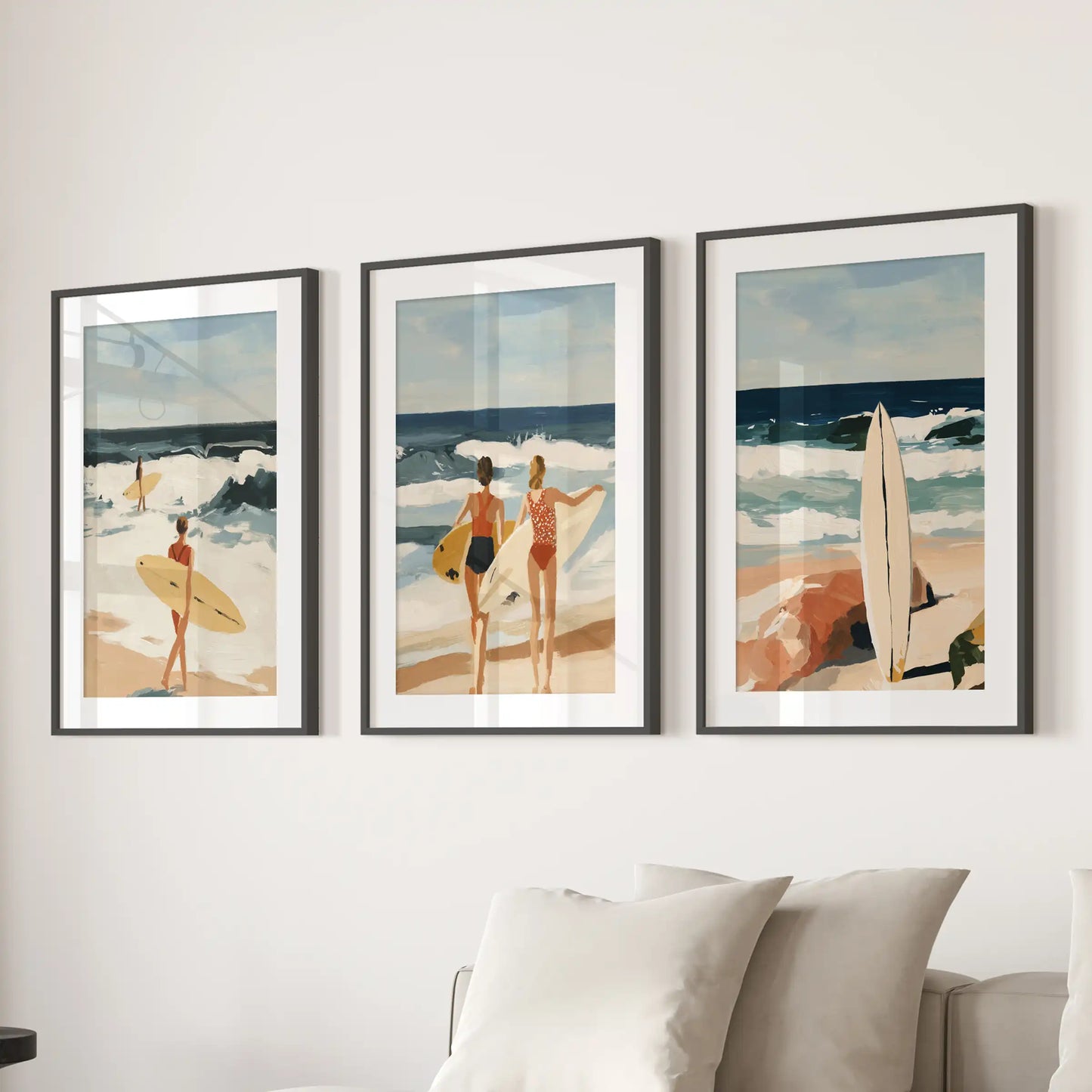 Three ocean-wave wall pieces in black-matted frames line the wall behind the sofa, giving the sitting room a calm, seaside balance.