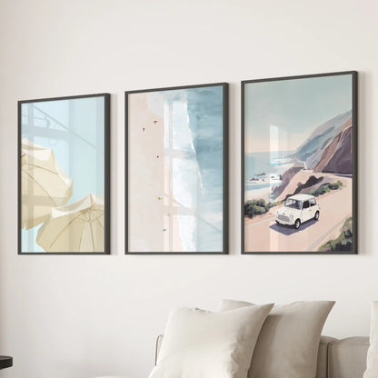 A set of three black-framed coastal road trip prints spans the lounge wall over the sofa, layering a breezy narrative in one view.