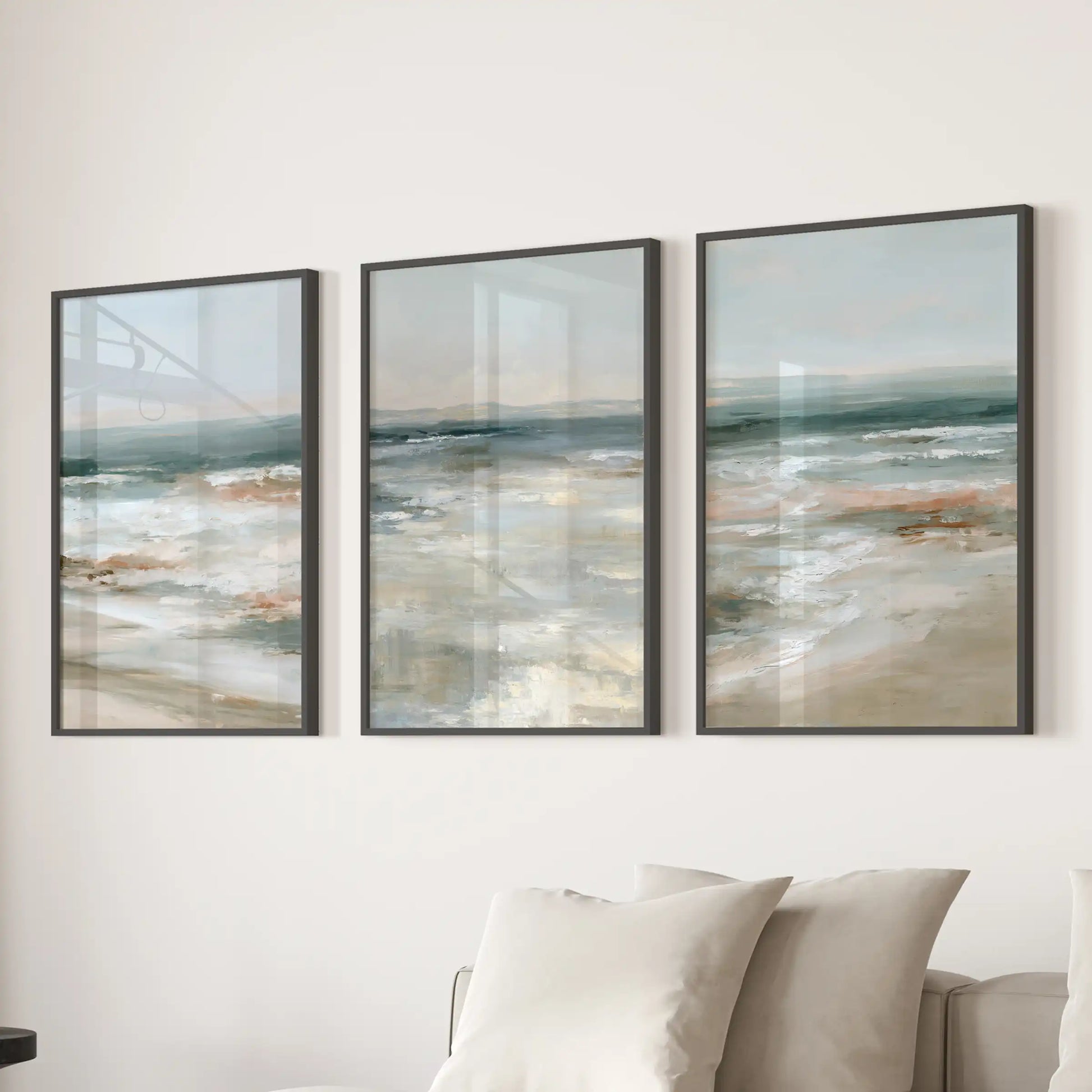 Distant sea horizon poster set of three brings airy wall art in slim black frames above the sofa, freshening the living room with soft blues.