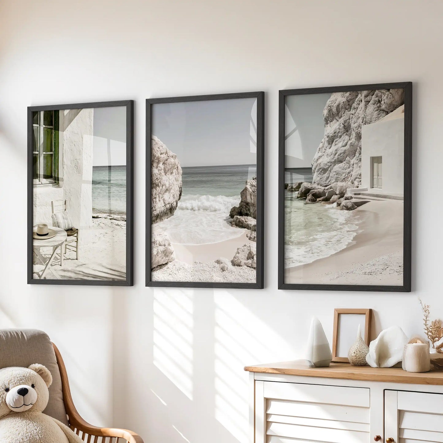 Minimalist ocean scenes, print trio set in black frames, sit above the dresser to soften a kids room with gentle sand, surf, and horizon lines.