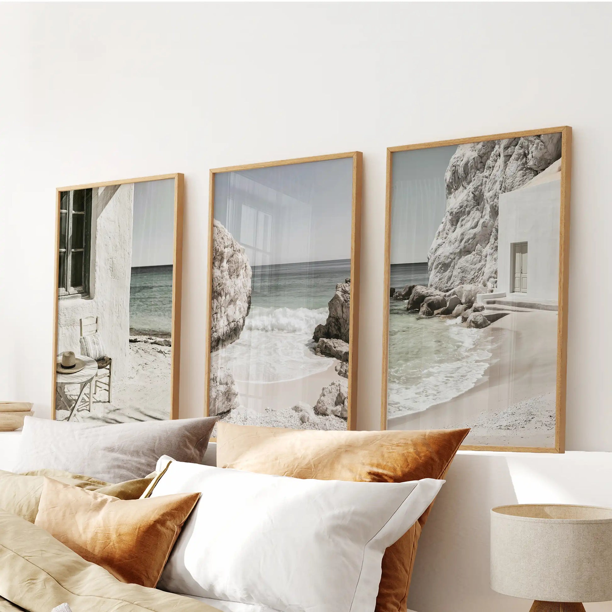 Minimalist ocean scenes, three piece artwork in light oak frames, span over the bed to keep the bedroom serene with balanced horizon and tide.