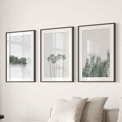 Pastel seaside landscape set of three prints softens the family room, shown in black mat frames and arranged over the sectional.