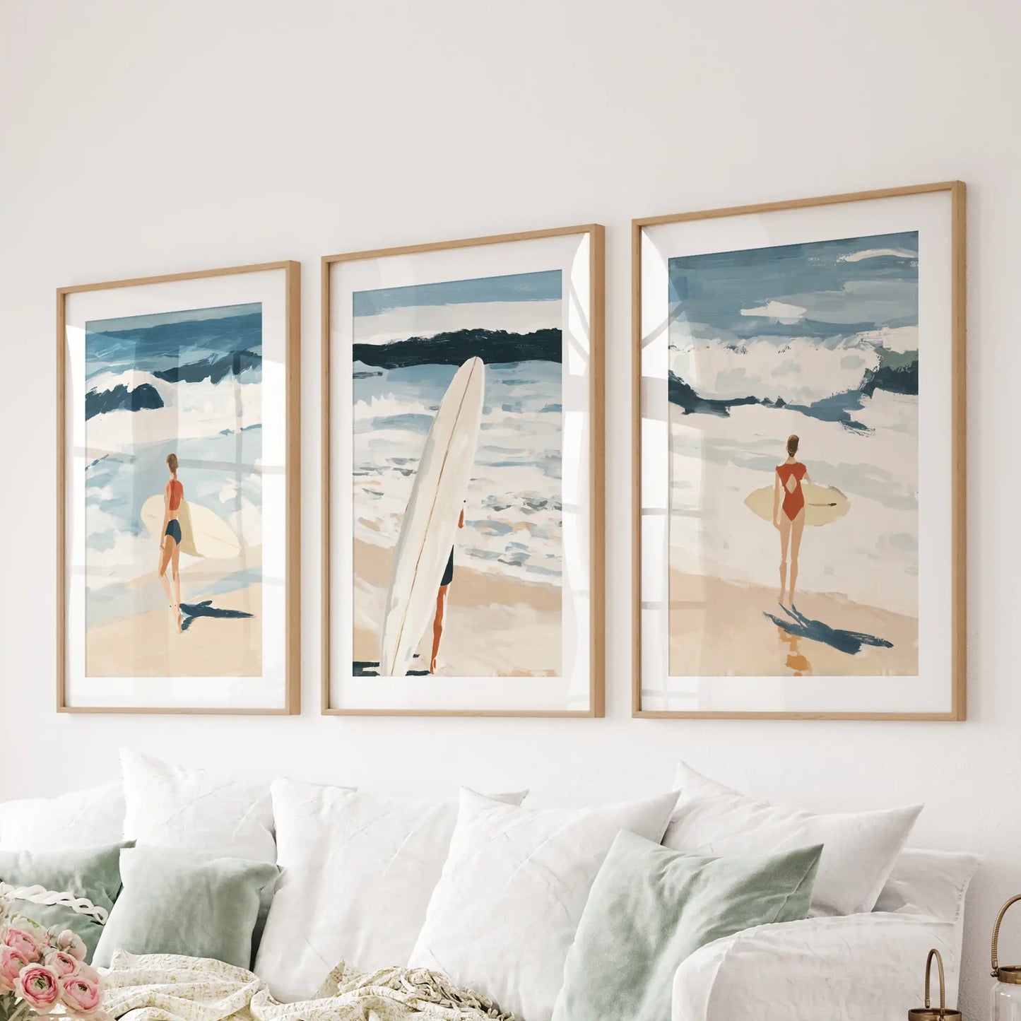 Coastal beach vistas, a three-piece wall hanging in natural wood frames with mats, grounds the sitting room above the couch.