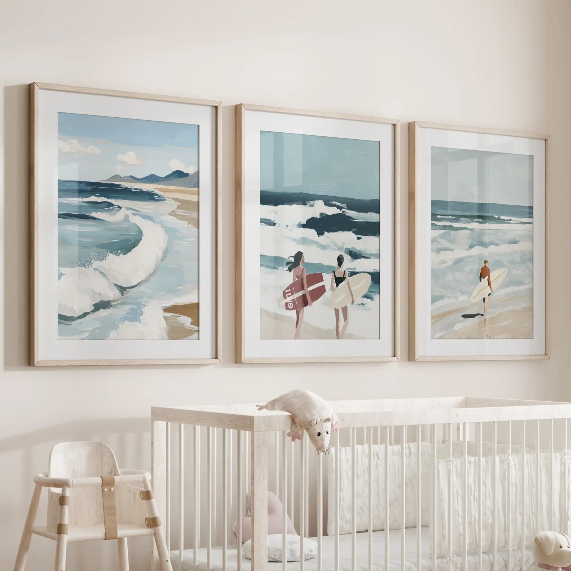 Coastal surf art set of three in wood-matted frames hangs above the cot, filling the nursery with a soft, sea-breeze mood.