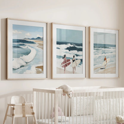 Coastal surf art set of three in wood-matted frames hangs above the cot, filling the nursery with a soft, sea-breeze mood.