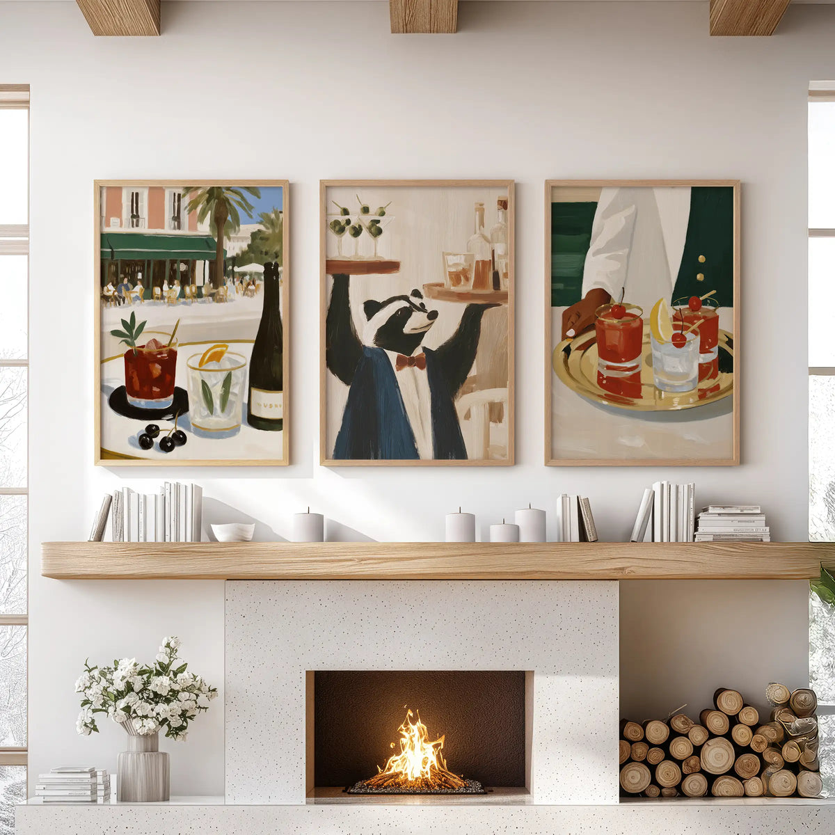 Set of three wall art prints featuring cocktails, displayed in light oak frames over a lounge fireplace mantel.
