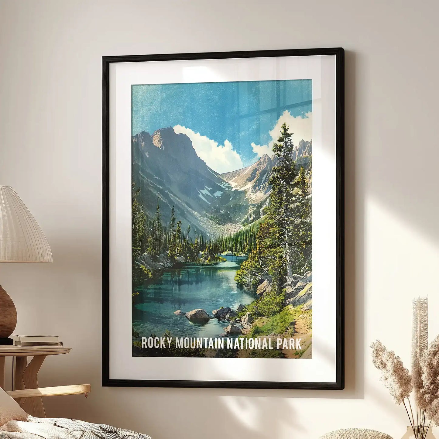 Framed with crisp black and white mat, this wall picture of snow-topped peaks and an alpine lake rests above a chair in a timeless sitting room.