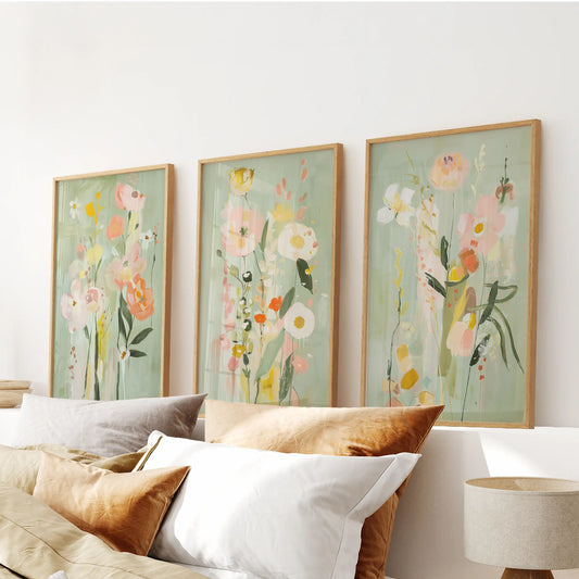 Three oak-framed floral paintings form bright wall art above the headboard, adding softness to the bedroom.