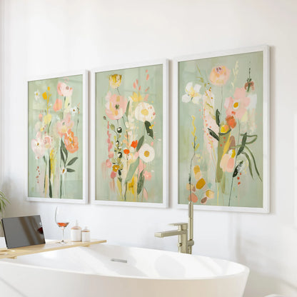 Three white-framed abstract floral prints hang above the bathtub, adding bright color and charm to the bathroom.