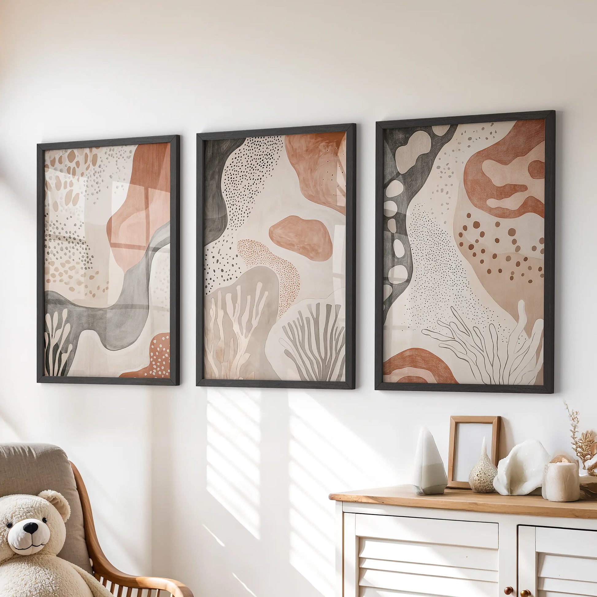 Three black-framed prints of organic mid-century forms add tidy balance above the dresser, suiting a playful kids’ room.